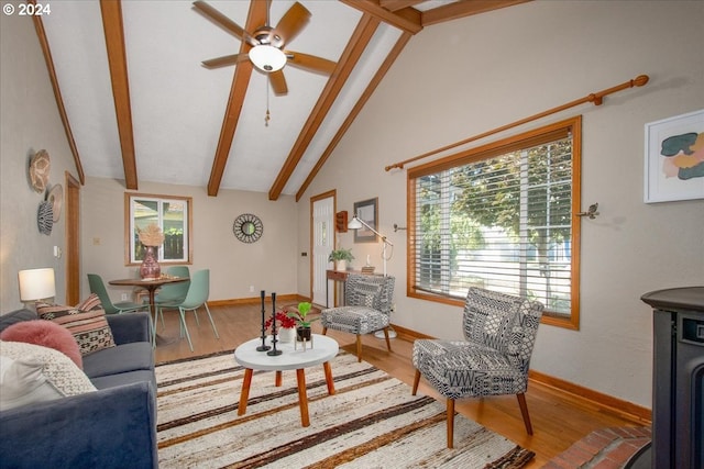 living room with ceiling fan, beamed ceiling, a wealth of natural light, and hardwood / wood-style flooring