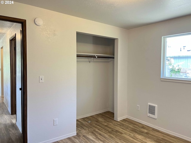 unfurnished bedroom with a closet and hardwood / wood-style flooring