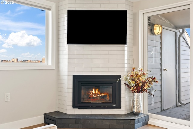 interior details featuring a glass covered fireplace and baseboards