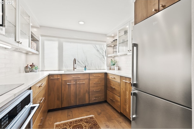 kitchen with dark wood-style floors, appliances with stainless steel finishes, a sink, and white cabinets