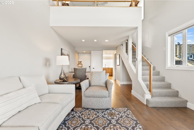 living room with recessed lighting, wood finished floors, baseboards, and stairs