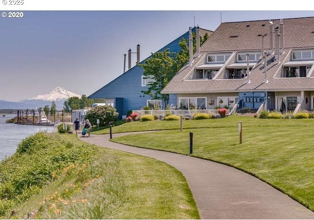 surrounding community with a yard and a water and mountain view