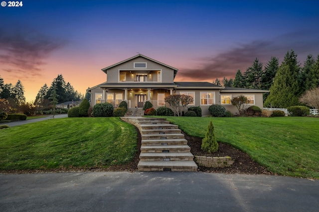 view of front of home featuring covered porch and a yard