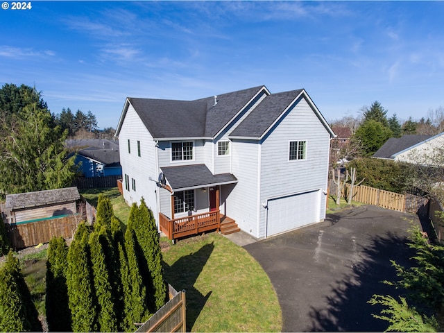 view of front of house featuring a wooden deck, a front yard, and a garage