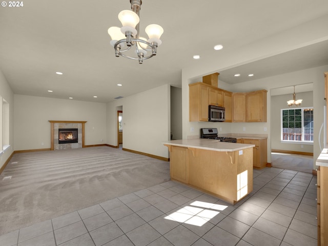 kitchen featuring hanging light fixtures, stainless steel appliances, light tile floors, and a notable chandelier