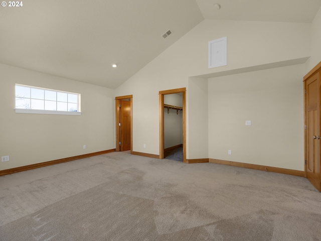 unfurnished room featuring high vaulted ceiling and light carpet