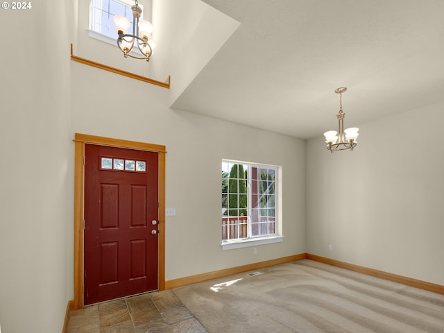 carpeted foyer with a notable chandelier