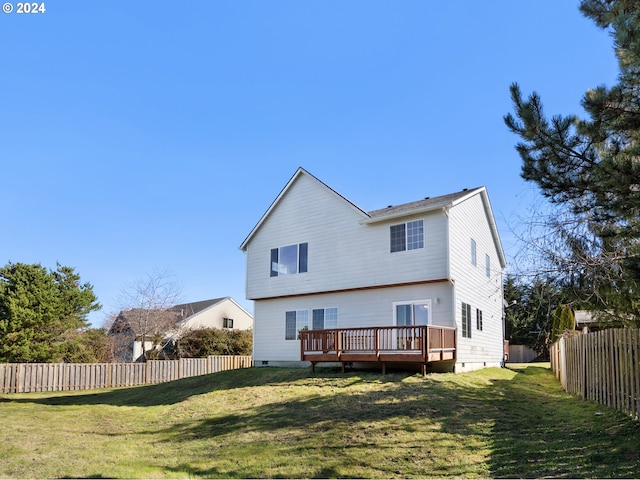 rear view of house featuring a wooden deck and a lawn