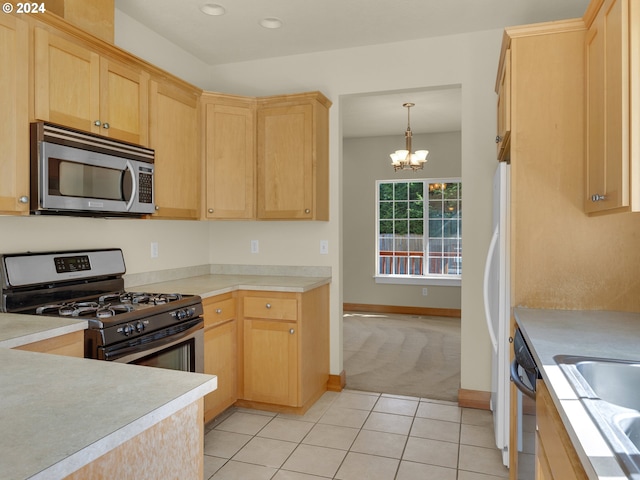 kitchen with pendant lighting, light tile floors, appliances with stainless steel finishes, light brown cabinets, and a notable chandelier