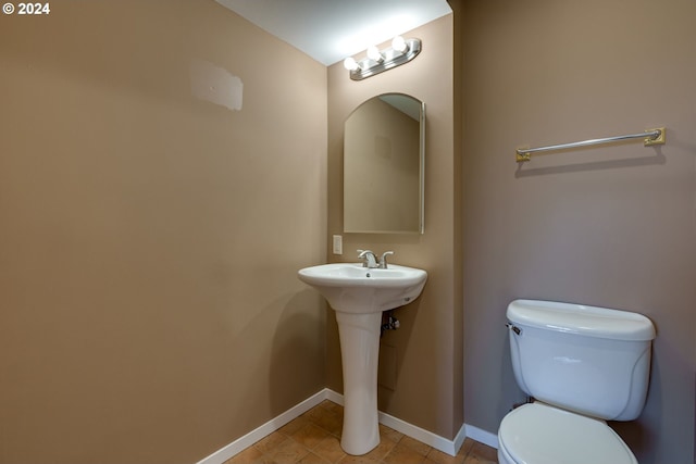 bathroom featuring tile floors and toilet