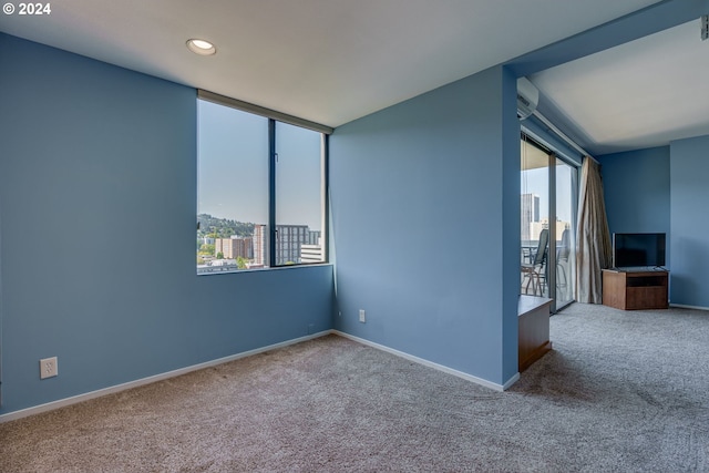 carpeted empty room with plenty of natural light and a wall mounted air conditioner