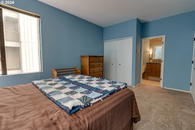 bedroom featuring multiple windows, a closet, connected bathroom, and carpet flooring