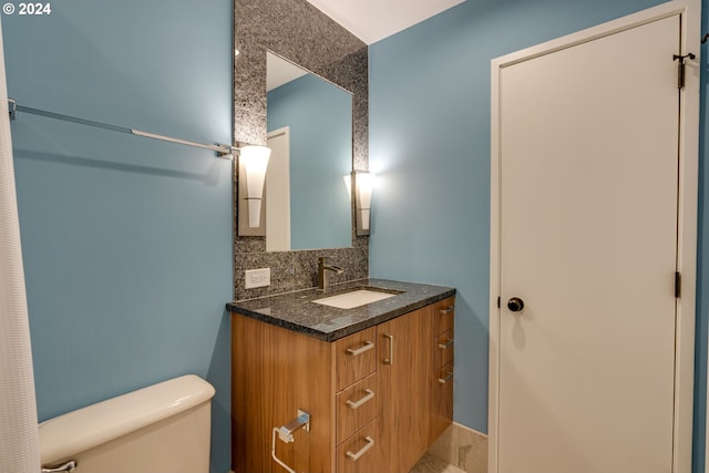 bathroom with oversized vanity, tasteful backsplash, and toilet