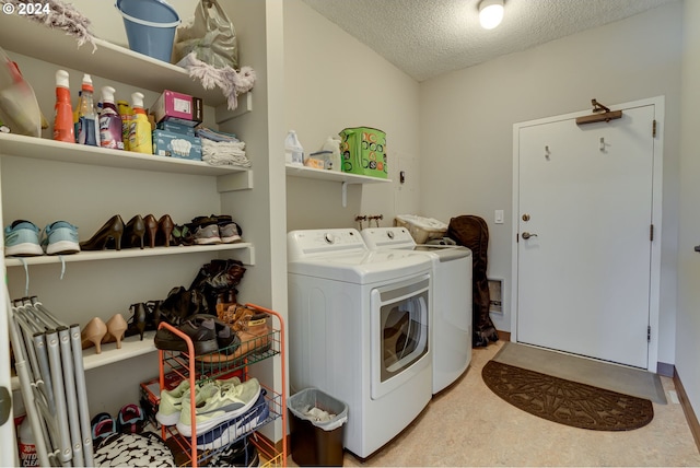 clothes washing area featuring a textured ceiling and washer and clothes dryer