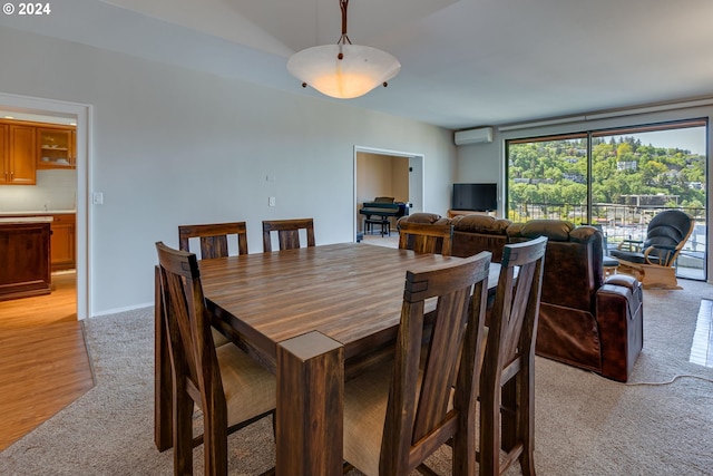 dining room with light hardwood / wood-style flooring and a wall mounted AC