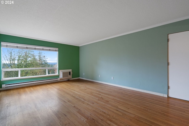 unfurnished room featuring hardwood / wood-style flooring, a textured ceiling, a wall mounted AC, and a baseboard heating unit