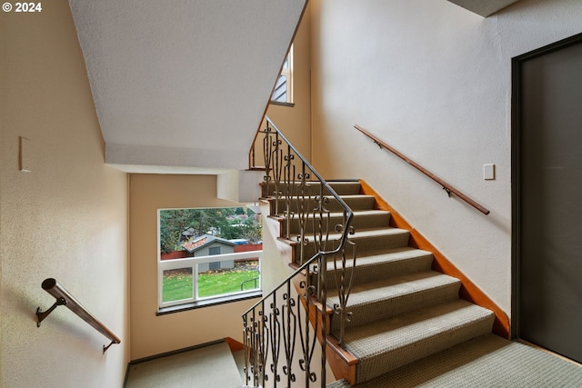 staircase with carpet flooring and a textured ceiling