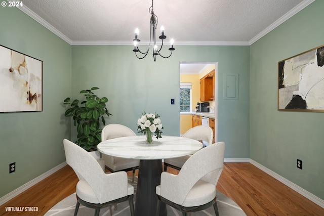 dining space featuring light hardwood / wood-style floors, crown molding, and a textured ceiling