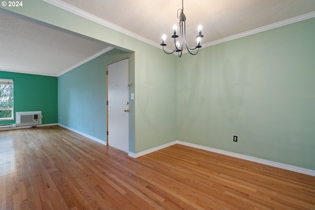 unfurnished room featuring a textured ceiling, a wall mounted AC, a notable chandelier, and light wood-type flooring