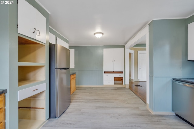 kitchen with light hardwood / wood-style flooring, appliances with stainless steel finishes, and white cabinets