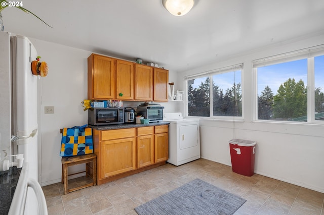 kitchen featuring washer / dryer and white fridge