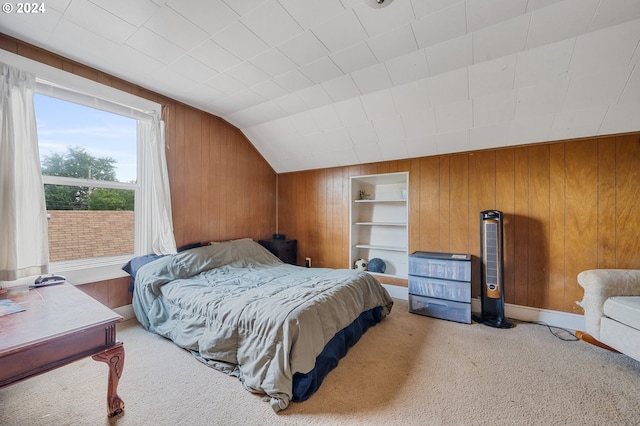 bedroom featuring lofted ceiling, wood walls, and carpet