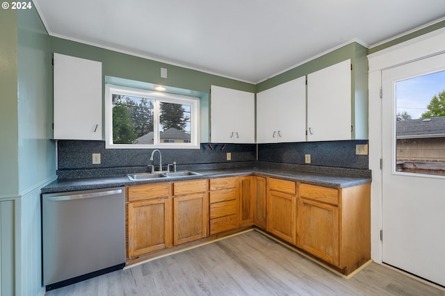 kitchen featuring light wood-type flooring, backsplash, sink, stainless steel dishwasher, and white cabinets