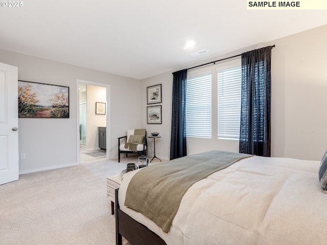 bedroom featuring connected bathroom and light colored carpet