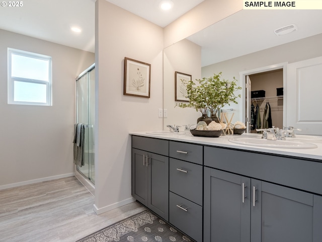 bathroom with walk in shower, vanity, and hardwood / wood-style flooring