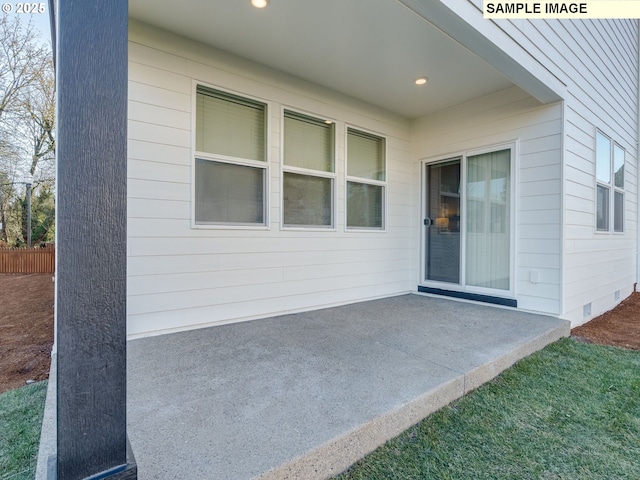 view of exterior entry with a patio