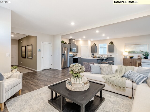 kitchen featuring a breakfast bar area, dark brown cabinets, stainless steel appliances, a center island, and dark hardwood / wood-style flooring