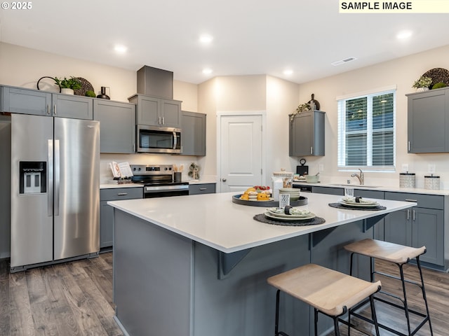 kitchen featuring tasteful backsplash, dark brown cabinets, dark hardwood / wood-style floors, a kitchen island, and stainless steel appliances