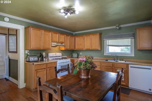 kitchen featuring dark wood-type flooring, white appliances, ornamental molding, and sink