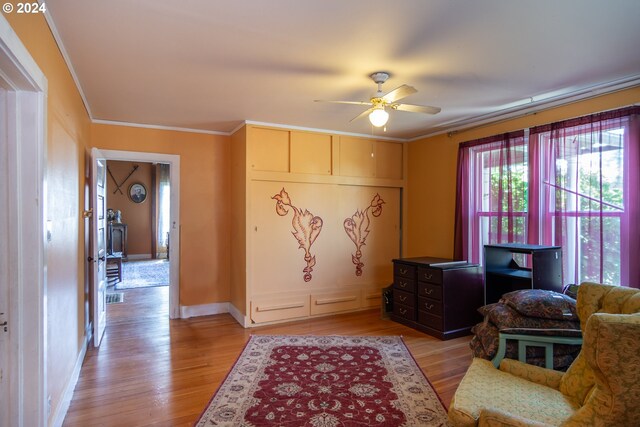 sitting room with crown molding, ceiling fan, and light hardwood / wood-style floors