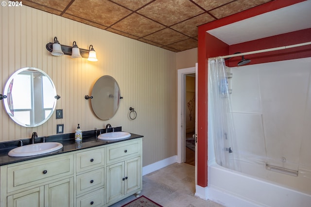 bathroom featuring shower / bath combination with curtain, a drop ceiling, and vanity