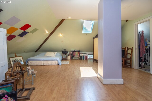 bedroom with light hardwood / wood-style floors and vaulted ceiling