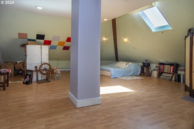 bedroom featuring vaulted ceiling with skylight and wood finished floors