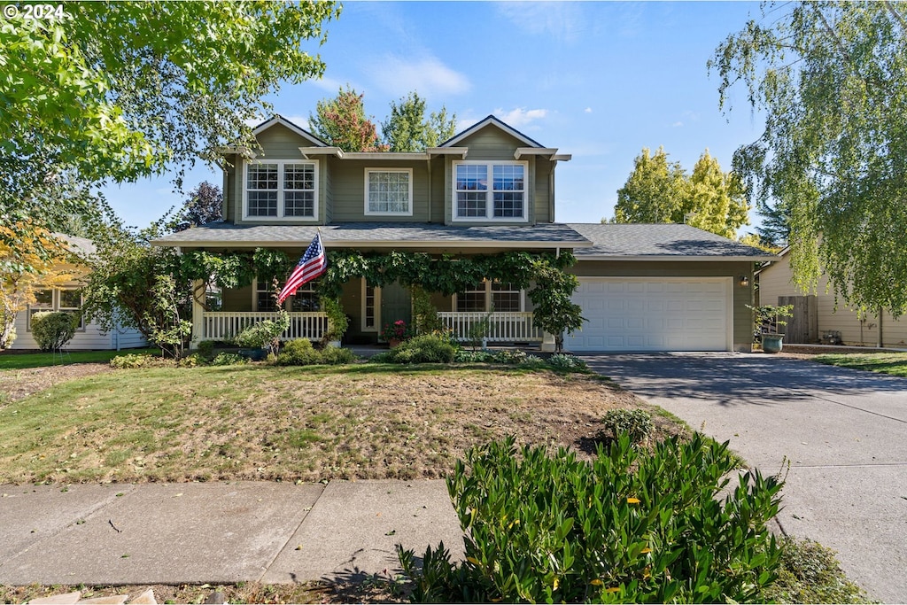 view of front of home featuring a garage, a front lawn, and a porch