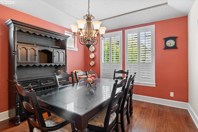 dining room featuring a textured ceiling, dark hardwood / wood-style floors, and an inviting chandelier