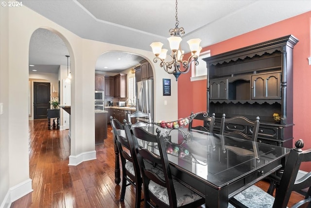 dining room featuring dark hardwood / wood-style flooring, sink, and an inviting chandelier