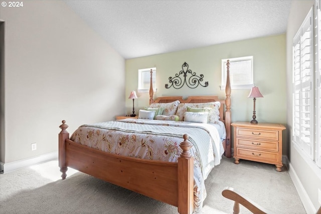 carpeted bedroom with vaulted ceiling and a textured ceiling