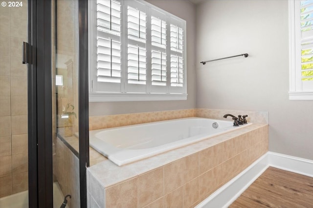 bathroom featuring plenty of natural light and tiled tub