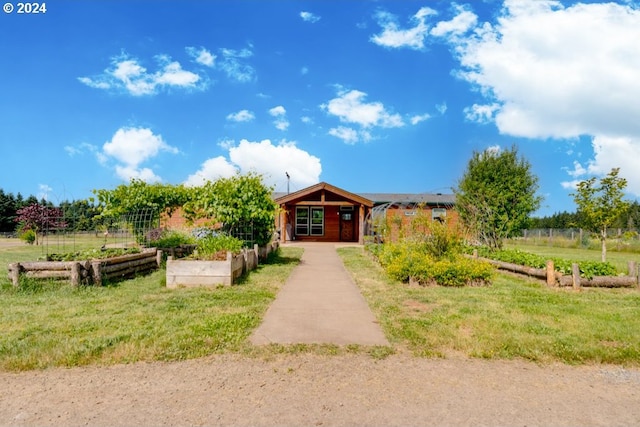 view of front of home with a rural view and a front yard