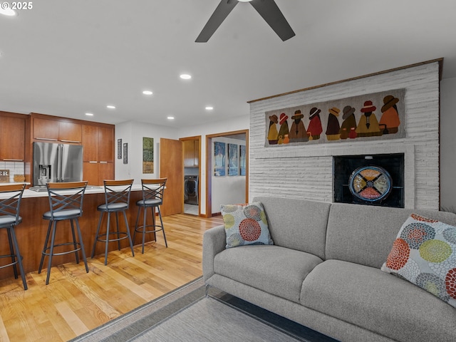 living room with washer / clothes dryer, light wood-style floors, recessed lighting, and ceiling fan