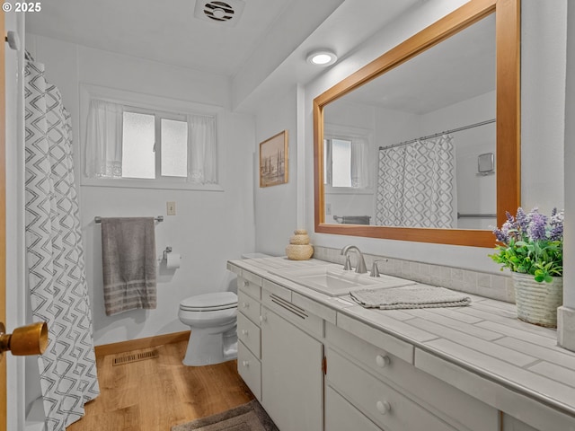 bathroom featuring vanity, toilet, wood finished floors, and visible vents