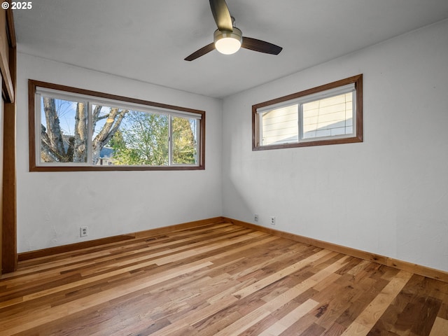 spare room featuring ceiling fan, baseboards, and wood finished floors