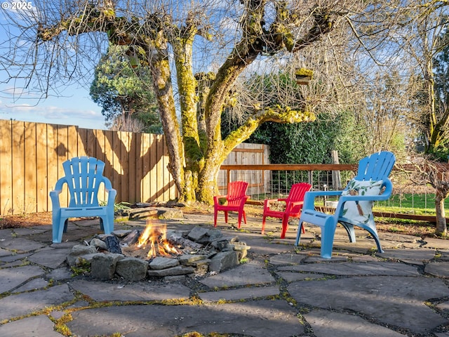 view of community with a patio, a fire pit, and fence