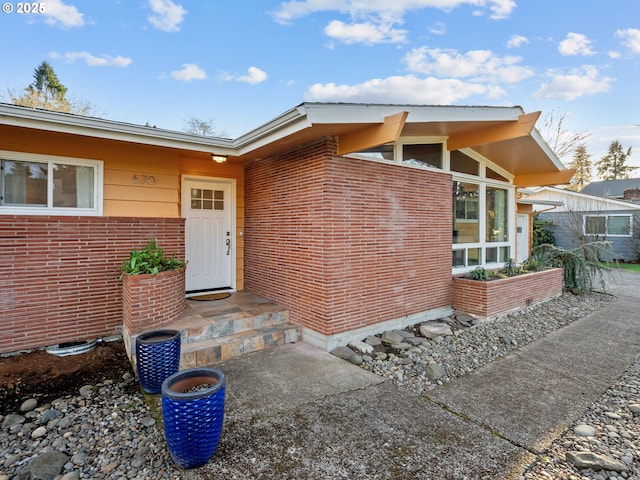 doorway to property featuring brick siding