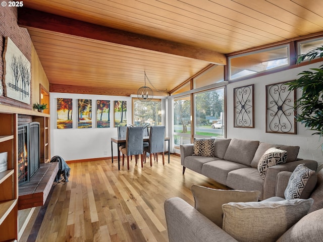 sunroom featuring a chandelier, wood ceiling, lofted ceiling with beams, and a lit fireplace