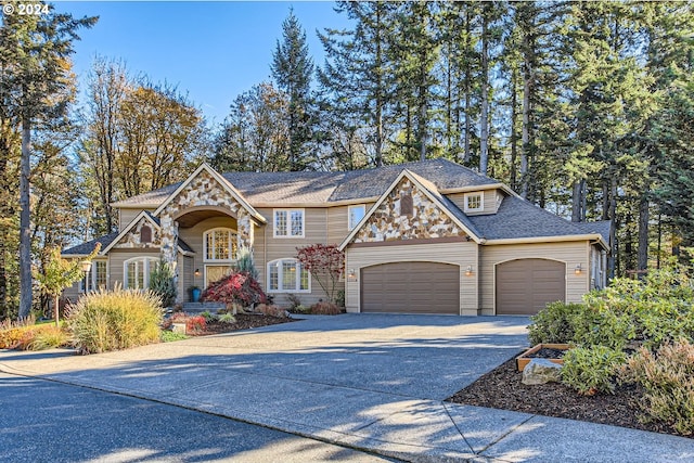 view of front of home with a garage, stone siding, concrete driveway, and roof with shingles